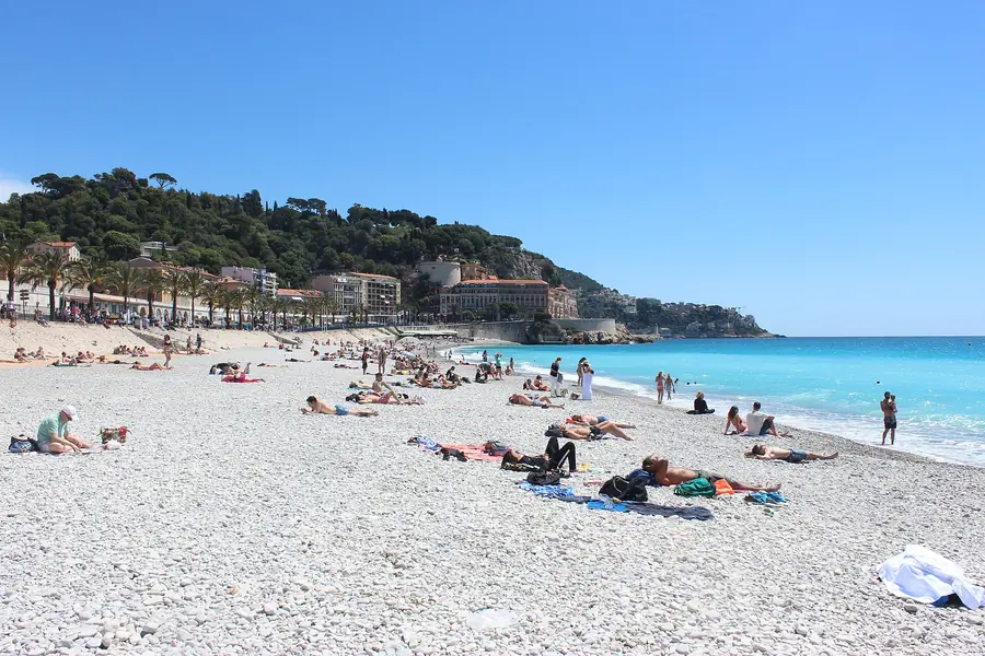 The pebble beach and blue water along the Promenade des Anglais in Nice