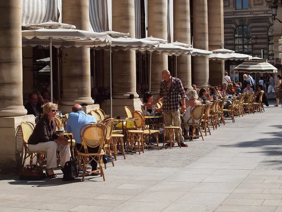 Rattan chairs on a café terrace under the arcades of Place Colette, Paris